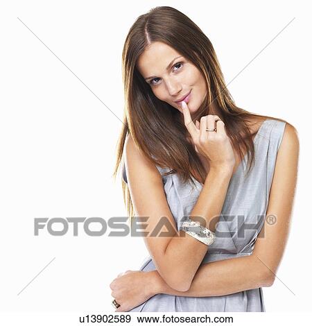 Portrait of attractive woman smiling with finger on lip against white background View Large Photo Image Stock Photo - Portrait of attractive woman smiling with finger on lip against white background. Fotosearch