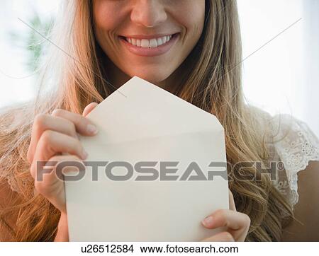 Picture - Portrait of blonde woman holding envelope. Fotosearch