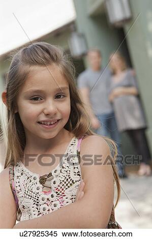 Portrait of cheerful girl (6-7) with parents in background View Large Photo Image Stock Photography - Portrait of cheerful girl (6-7) with parents in background. Fotosearch