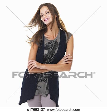 Portrait of cute young woman standing with arms crossed View Large Photo Image Stock Photo - Portrait of cute young woman standing with arms crossed. Fotosearch
