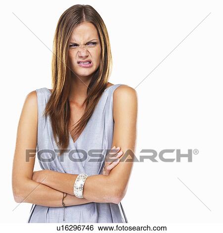 Stock Photograph - Portrait of disgusted woman standing with hands folded. Fotosearch
