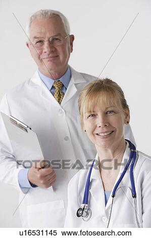 Stock Photography - Portrait of female and male doctor, studio shot. Fotosearch