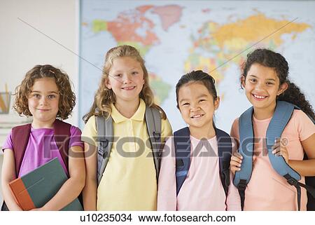Picture - Portrait of four girls (6-9) carrying backpacks. Fotosearch
