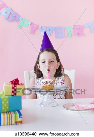 Stock Image - Portrait of girl (6-7) celebrating birthday. Fotosearch
