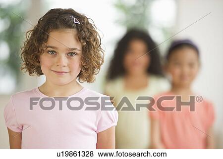 Stock Photo - Portrait of girl (6-7) with friends. Fotosearch