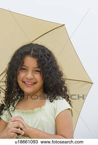 Stock Image - Portrait of girl (8-9) with umbrella. Fotosearch