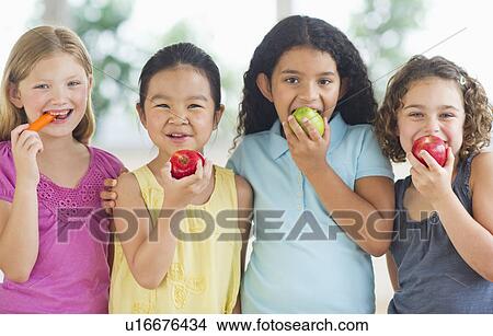 Portrait of girls (6-9) eating fruits View Large Photo Image Picture - Portrait of girls (6-9) eating fruits. Fotosearch
