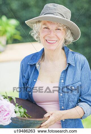 Stock Image - Portrait of senior women in back yard. Fotosearch