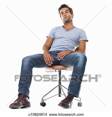 Portrait of smart young man sitting comfortably on chair against white background View Large Photo Image Picture - Portrait of smart young man sitting comfortably on chair against white background. Fotosearch