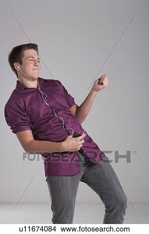 Portrait of smiling teenager playing air guitar, studio shot View Large Photo Image Picture - Portrait of smiling teenager playing air guitar, studio shot. Fotosearch