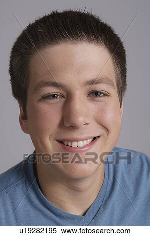 Stock Photography - Portrait of smiling teenager, studio shot. Fotosearch