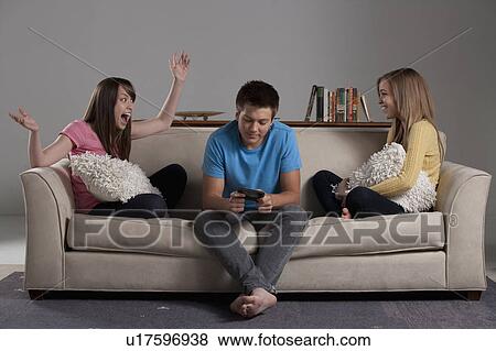 Stock Photo - Portrait of teenage boy (16-17) and girl (16-17) with young friend. Fotosearch