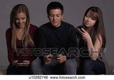 Portrait of teenage boy (16-17) and girl (16-17) with young friend, studio shot View Large Photo Image Stock Photograph - Portrait of teenage boy (16-17) and girl (16-17) with young friend, studio shot. Fotosearch