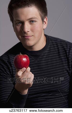 Portrait of teenage boy (16-17) with red apple, studio shot View Large Photo Image Stock Photo - Portrait of teenage boy (16-17) with red apple, studio shot. Fotosearch
