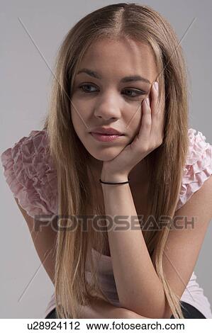 Stock Image - Portrait of teenage girl (16-17), studio shot. Fotosearch
