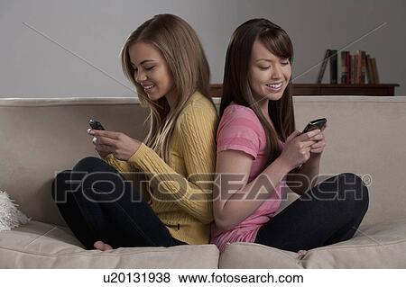 Portrait of teenage girl (16-17) with young woman sitting on sofa View Large Photo Image Stock Photo - Portrait of teenage girl (16-17) with young woman sitting on sofa. Fotosearch