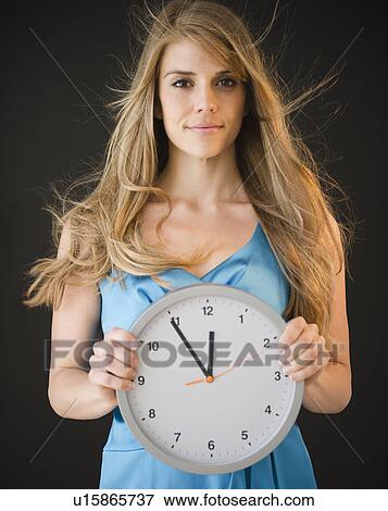 Portrait of woman holding clock View Large Photo Image Stock Photo - Portrait of woman holding clock. Fotosearch