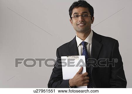 Stock Image - Portrait of young businessman, studio shot. Fotosearch