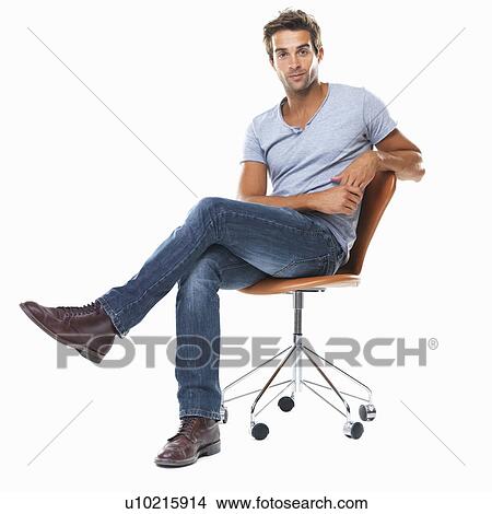 Picture - Portrait of young man sitting on chair with legs crossed against white background. Fotosearch
