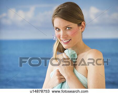 Portrait of young woman holding towel by sea View Large Photo Image Stock Image - Portrait of young woman holding towel by sea. Fotosearch