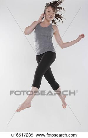 Portrait of young woman jumping, studio shot View Large Photo Image Stock Photography - Portrait of young woman jumping, studio shot. Fotosearch