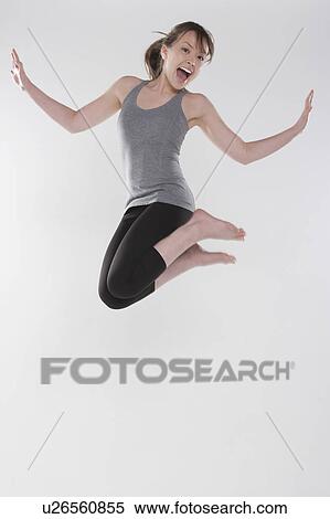 Portrait of young woman jumping, studio shot View Large Photo Image Stock Photography - Portrait of young woman jumping, studio shot. Fotosearch
