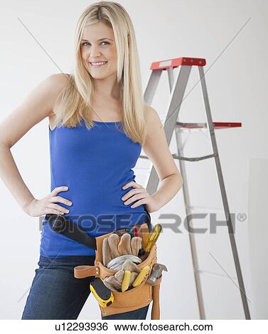 Portrait of young woman wearing tool belt View Large Photo Image Stock Photograph - Portrait of young woman wearing tool belt. Fotosearch