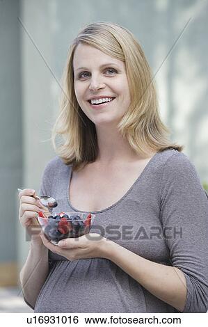Pregnant woman eating fresh berries View Large Photo Image Stock Photograph - Pregnant woman eating fresh berries. Fotosearch