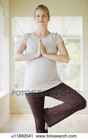 Stock Image - Pregnant woman practicing yoga. Fotosearch