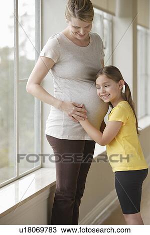 Stock Image - Pregnant woman with daughter (6-7). Fotosearch