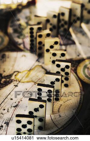 Row of dominoes on old world map View Large Photo Image Stock Image - Row of dominoes on old world map. Fotosearch
