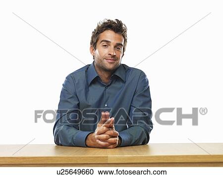 Smiling business man sitting at table with hands clasped View Large Photo Image Stock Image - Smiling business man sitting at table with hands clasped. Fotosearch