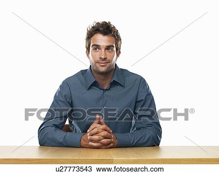 Smiling business man sitting at table with hands clasped View Large Photo Image Stock Image - Smiling business man sitting at table with hands clasped. Fotosearch