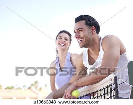 Smiling couple standing near tennis net View Large Photo Image Stock Photo - Smiling couple standing near tennis net. Fotosearch