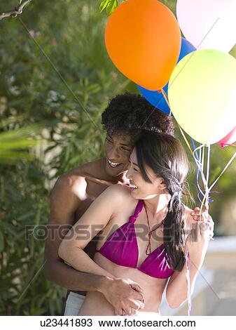 Smiling couple with balloons View Large Photo Image Stock Image - Smiling couple with balloons. Fotosearch