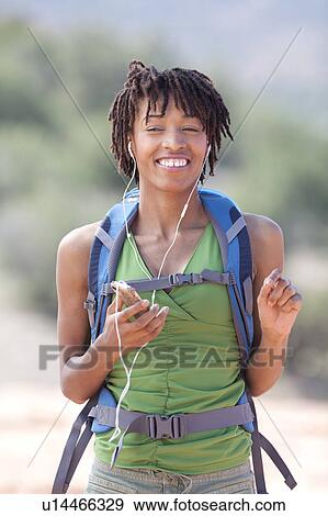 Smiling female hiker listening music View Large Photo Image Stock Photo - Smiling female hiker listening music. Fotosearch