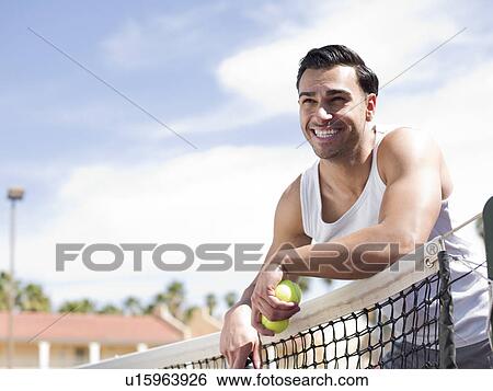 Smiling man standing near tennis net View Large Photo Image Stock Photograph - Smiling man standing near tennis net. Fotosearch