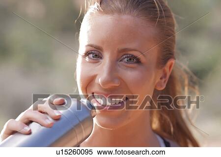 Smiling woman drinking water after jogging View Large Photo Image Stock Photography - Smiling woman drinking water after jogging. Fotosearch