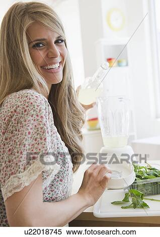 Smiling woman preparing drink View Large Photo Image Stock Photography - Smiling woman preparing drink. Fotosearch