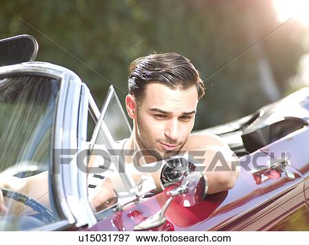 Smiling young man in convertible car View Large Photo Image Stock Photo - Smiling young man in convertible car. Fotosearch