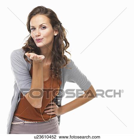 Stock Image - Studio portrait of attractive woman blowing kiss. Fotosearch