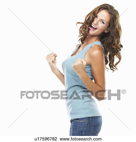 Stock Image - Studio portrait of attractive young woman with fists clenched. Fotosearch