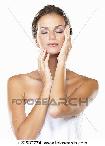 Studio portrait of beautiful woman wrapped in towel touching face View Large Photo Image Picture - Studio portrait of beautiful woman wrapped in towel touching face. Fotosearch
