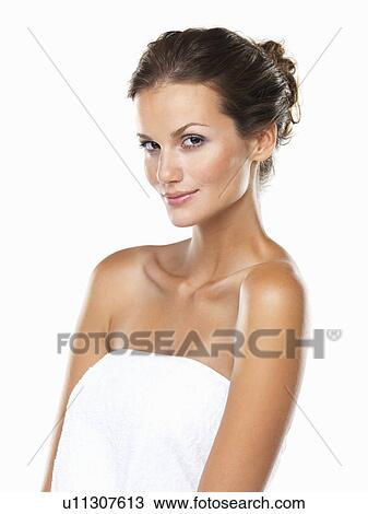 Stock Image - Studio portrait of beautiful woman wrapped in towel. Fotosearch