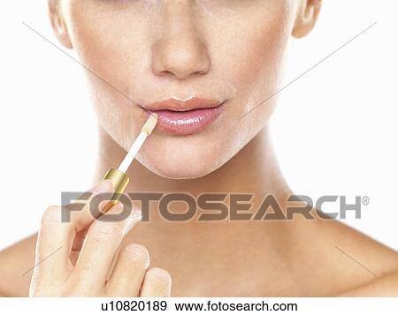 Studio portrait of beautiful woman applying lip gloss View Large Photo Image Stock Photo - Studio portrait of beautiful woman applying lip gloss. Fotosearch