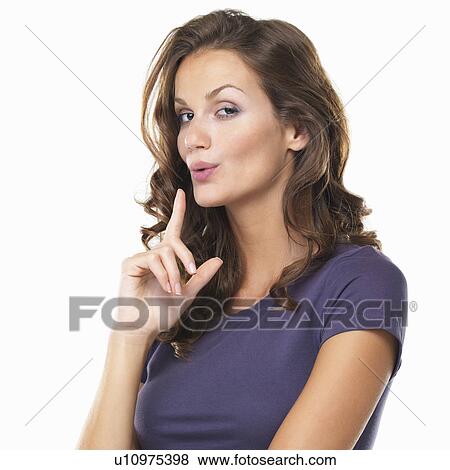 Stock Photo - Studio portrait of beautiful woman making gun shape with hand and blowing off imaginative smoke. Fotosearch
