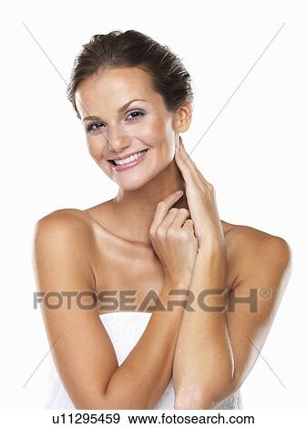 Stock Photo - Studio portrait of beautiful woman wrapped in towel touching neck. Fotosearch