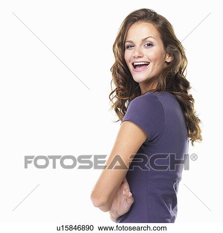 Stock Image - Studio portrait of beautiful young woman with hands folded and smiling. Fotosearch