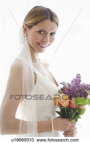 Studio portrait of bride holding floral bouquet View Large Photo Image Stock Image - Studio portrait of bride holding floral bouquet. Fotosearch