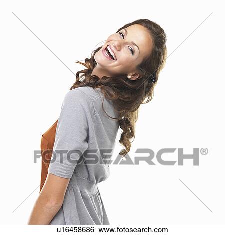 Studio portrait of happy young woman looking over shoulder and smiling View Large Photo Image Stock Photograph - Studio portrait of happy young woman looking over shoulder and smiling. Fotosearch